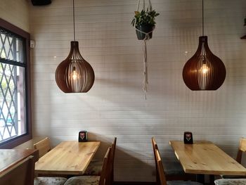 Illuminated pendant lights hanging over tables in restaurant