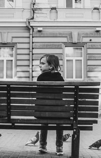 Kid looking away while sitting on bench