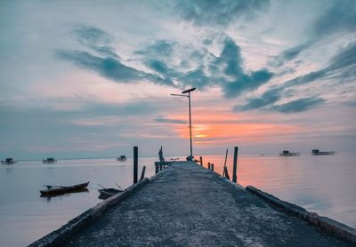 Pier over sea against sky during sunset