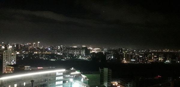 High angle view of illuminated buildings against sky at night