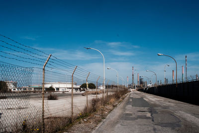 Street by road against blue sky