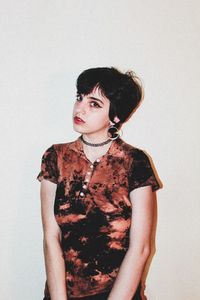 Portrait of young woman standing against white background