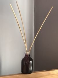 Close-up of sticks in bottle on table