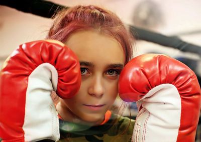 Close-up portrait of girl wearing boxing glove