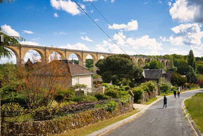 People walking on bridge against sky