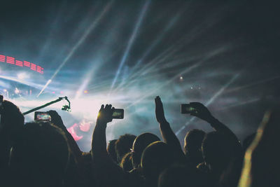 Silhouette people photographing at music concert