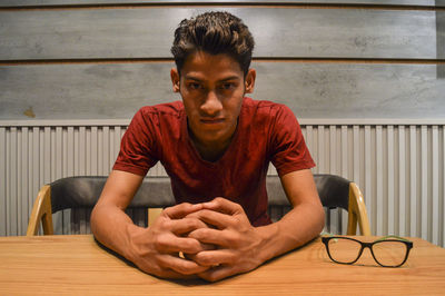 Portrait of young man sitting on table