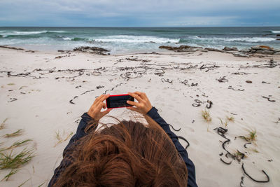Close-up of woman photographing on beach