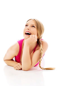 Young woman sitting against white background