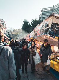 People standing on street market against sky