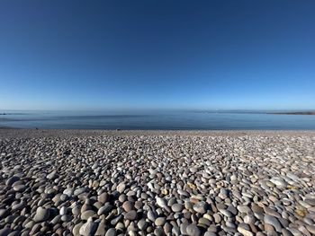 Stones on beach against clear sky