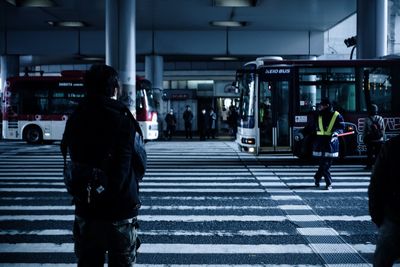 Rear view of people crossing road