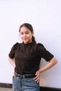 Portrait of young woman standing against sky