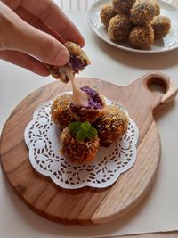 Cropped hand of person holding food on table