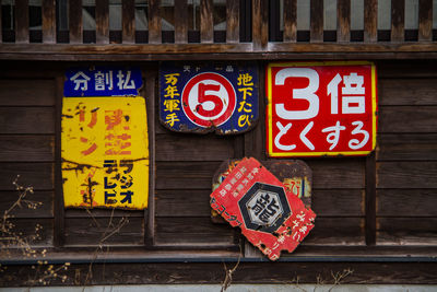 Close-up of information sign on wooden wall