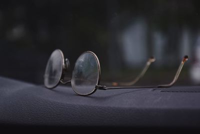 Close-up of eyeglasses on dashboard in car