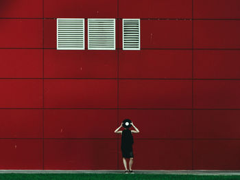 Rear view of man standing against yellow wall