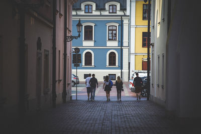 Rear view of people walking on building