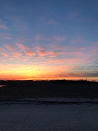 Scenic view of silhouette field against sky at sunset