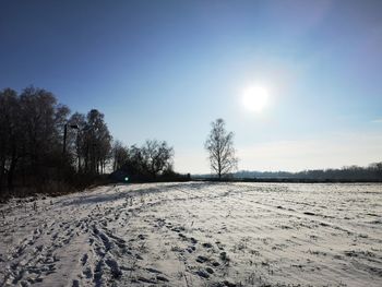 Scenic view of snow covered field against sky