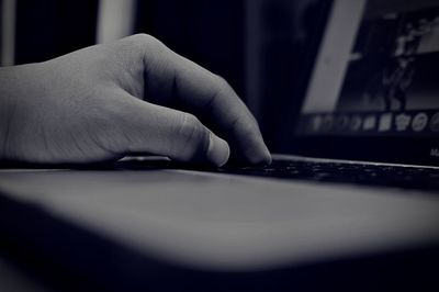 Cropped image of hand using laptop