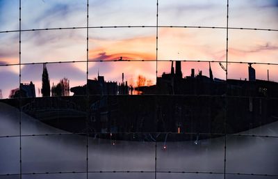 Silhouette buildings against sky during sunset in city