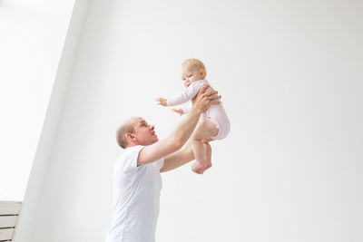 Side view of father with daughter against white background