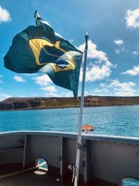 Low angle view of flag brazil on sea against sky