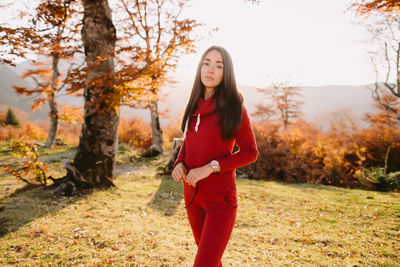 Young woman standing on field during autumn