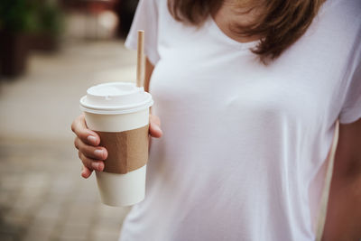 Midsection of woman holding coffee cup