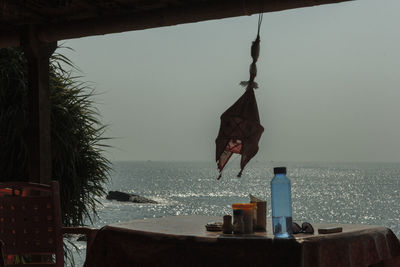 Clothes hanging on beach against sky