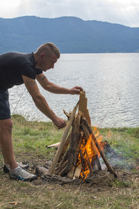 Side view of man burning campfire