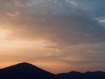 Low angle view of silhouette mountains against sky at sunset