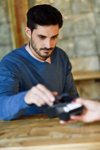 Young man swiping credit card on desk