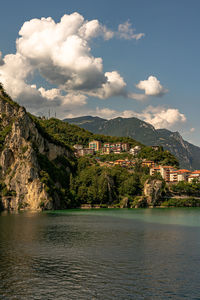 Scenic view of river by buildings against sky