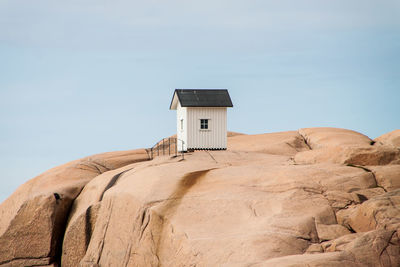 Low angle view of hut on rocks against sky