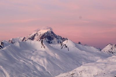 Scenic view of snow covered mountains against sky during sunset