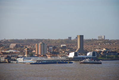 Scenic view of river and buildings against clear sky