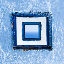 Close-up of blue window on white wall