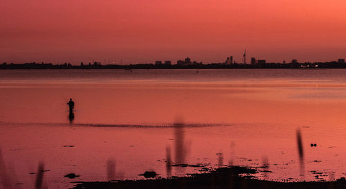 Scenic view of sea against orange sky