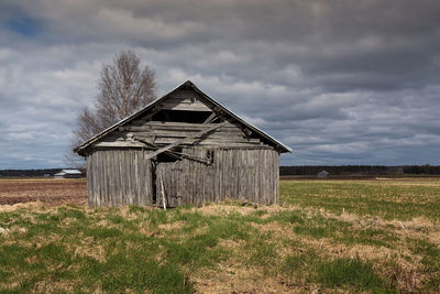 Wooden barn houses stand on the early summer fields of the rural finland.