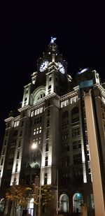 Low angle view of illuminated buildings against sky at night