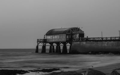 Built structure on beach against clear sky