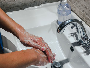 High angle view of hands in water at home