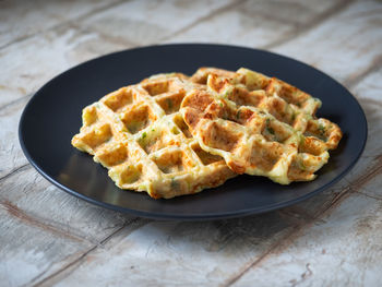 Zucchini waffles with the addition of greens and cheese on a close plate 