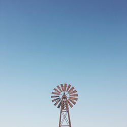 Low angle view of ferris wheel against clear blue sky