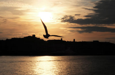 Sun shining through clouds over sea