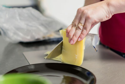 Slices of cheese on cutting board, woman cooking sandwiches for breakfast