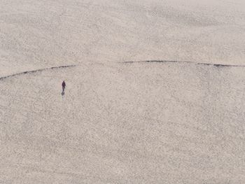 High angle view of man walking on sand