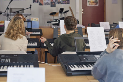 Teenagers attending keyboard lesson